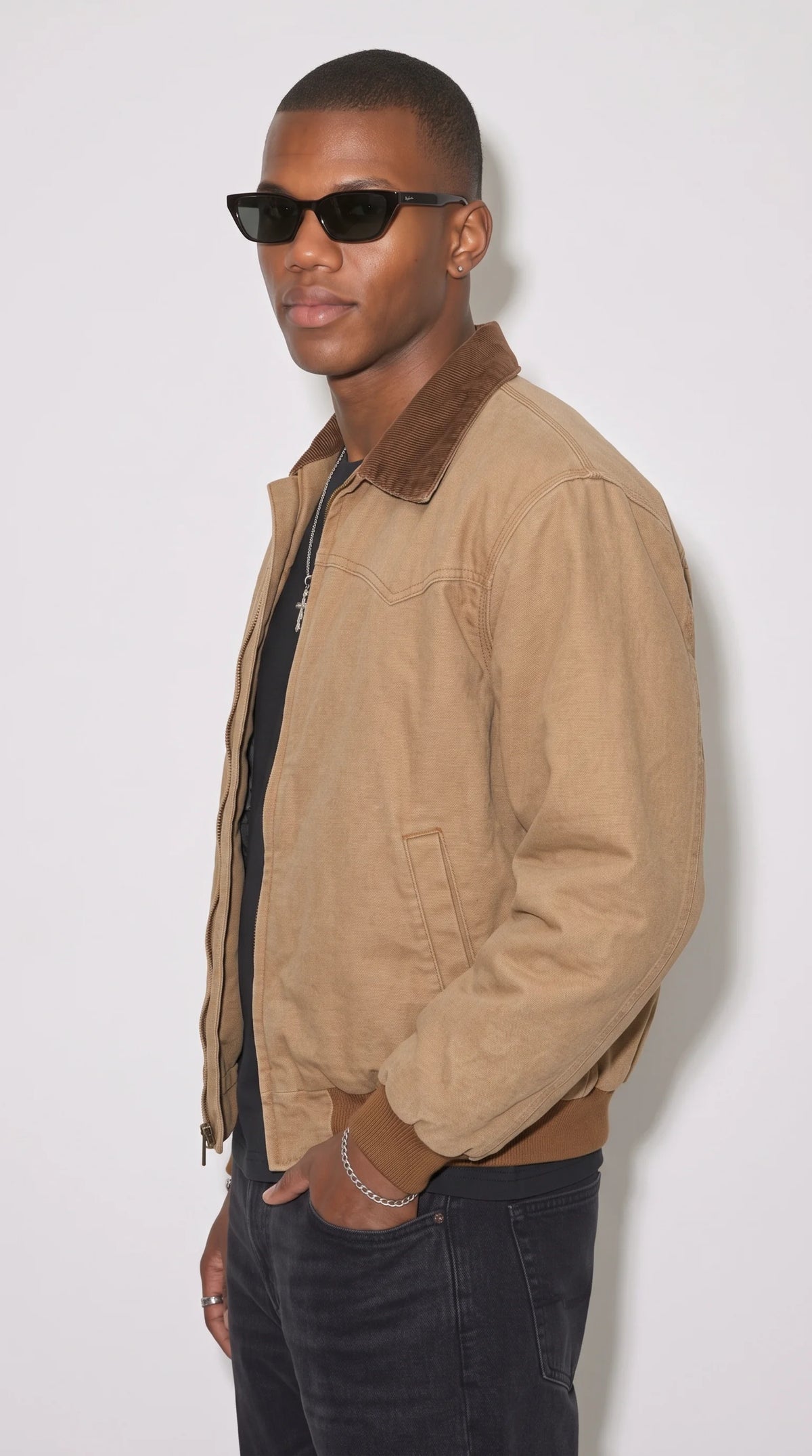 Light-brown heavyweight cotton bomber jacket with a slightly dropped shoulder line, two discreet side-entry pockets, reinforced panel stitching and a dark-brown ribbed hem, designed for comfortable everyday layering over T-shirts and lightweight knitwear.