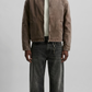 a minimalist brown cotton canvas jacket featuring a clean structured collar and button closure.