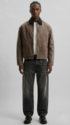 a minimalist brown cotton canvas jacket featuring a clean structured collar and button closure.