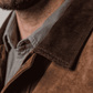 Close-up shot highlighting the rich, velvety texture of deep espresso brown suede fabric and high-quality premium stitching.