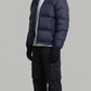 Studio portrait of a model wearing a versatile dark navy blue insulated winter jacket.