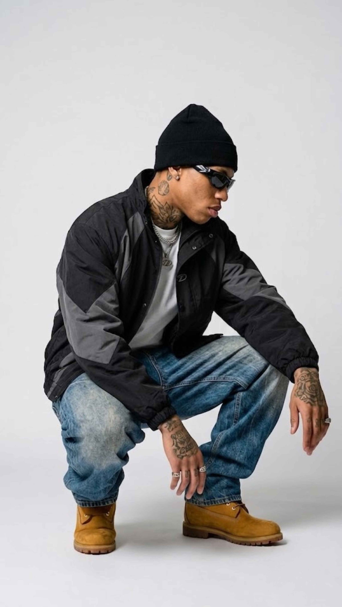 sitting view of side zip pockets and adjustable hem cinch cord on dark grey black Y2K jacket