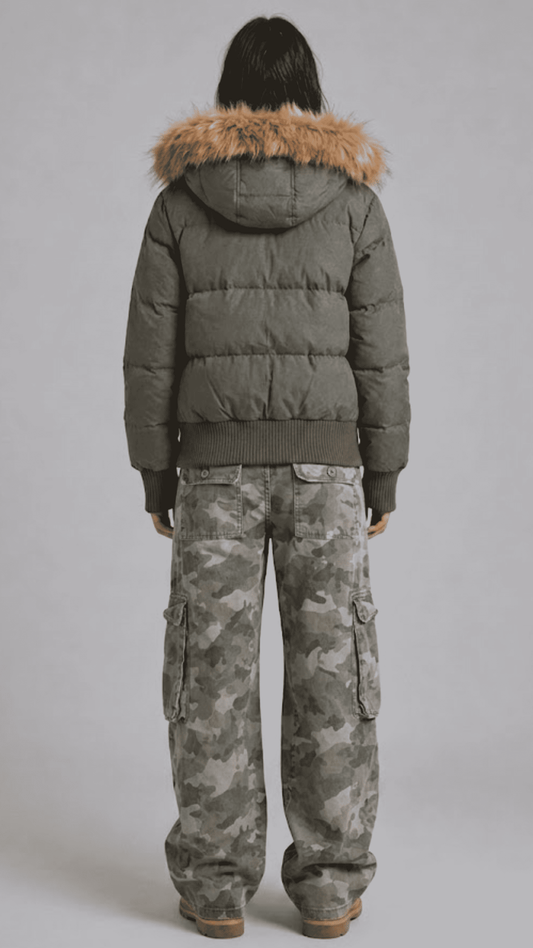 Rear view of loose fit olive puffer coat displaying broad horizontal quilted baffling and voluminous fur-trimmed hood