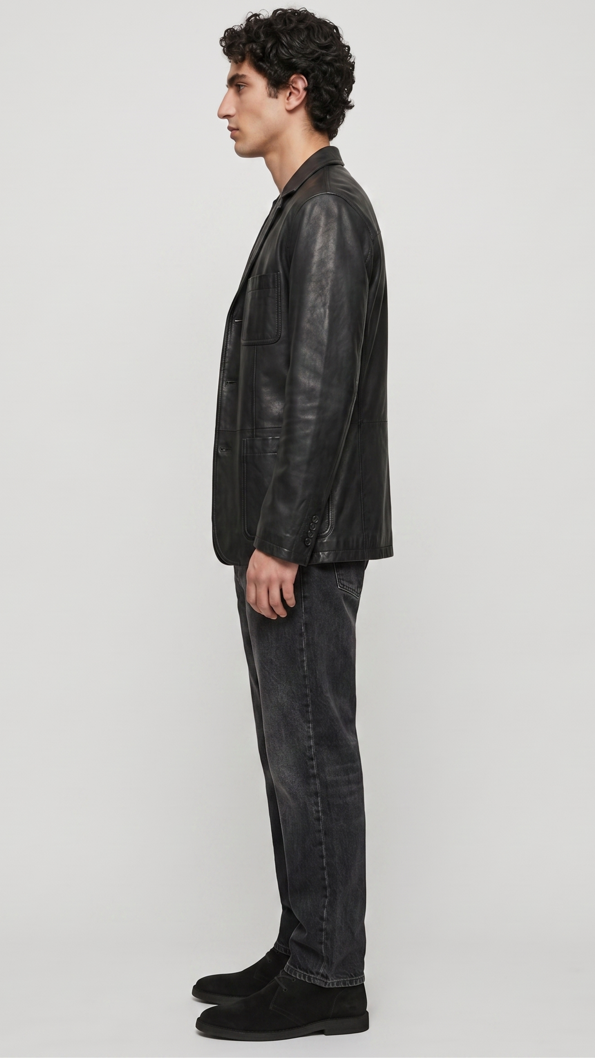 Sophisticated black leather blazer styled open over a monochrome dark outfit, perfect for urban evening luxury aesthetics.