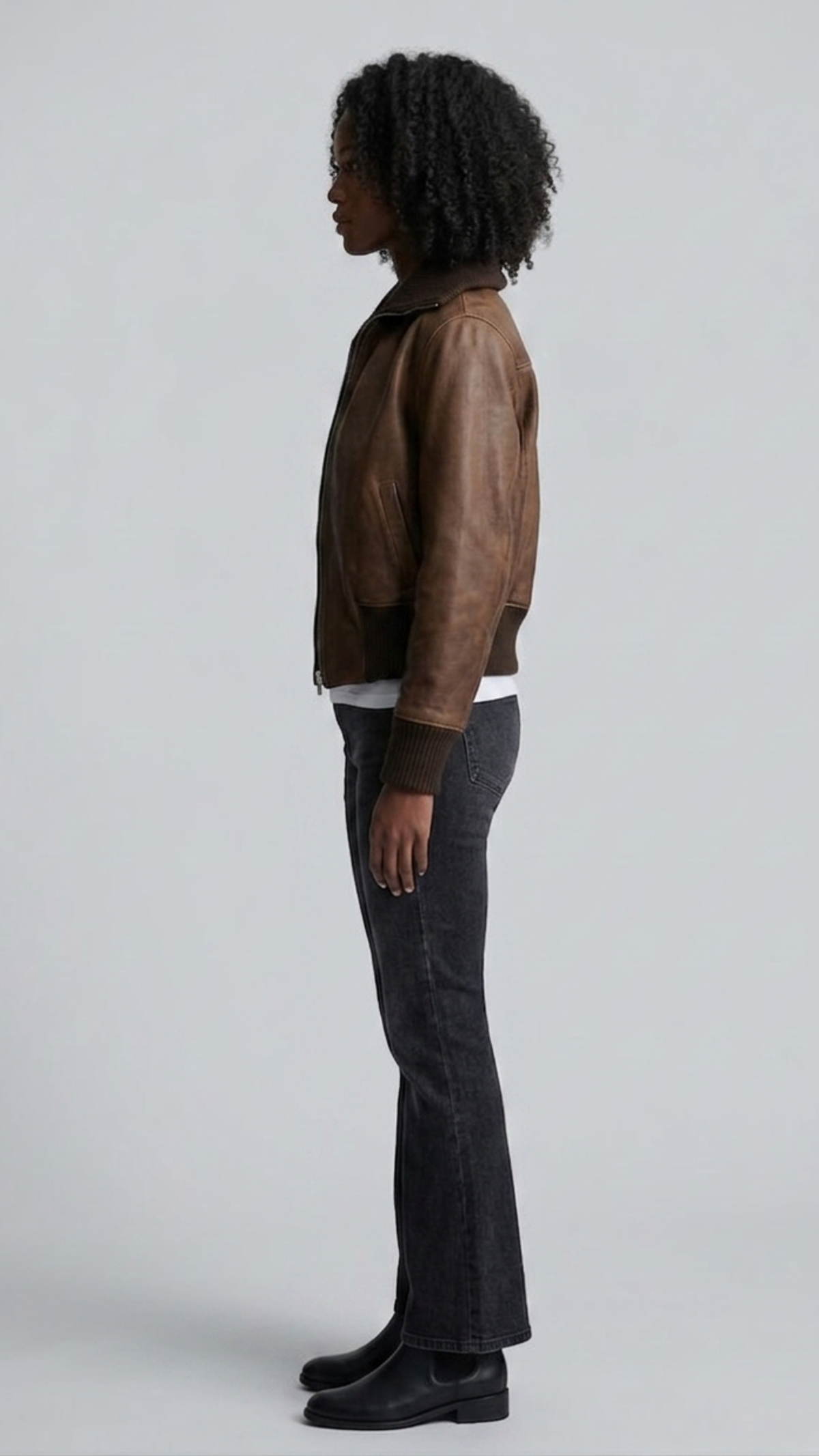 Side angle profile view detailing the durable matching dark brown elastic ribbed waistband and snug comfort cuffs of the flight outerwear.