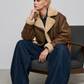 studio catalog photography of a model wearing a brown leather crop jacket with cream shearling lining and silver zipper details