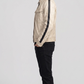 Side angle profile view highlighting the classic cafe racer band collar with a snap-button throat tab on the cream moto outerwear.