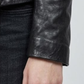 Close-up shot highlighting the smooth texture of the premium black leather and high-quality stitching on the blazer pocket.