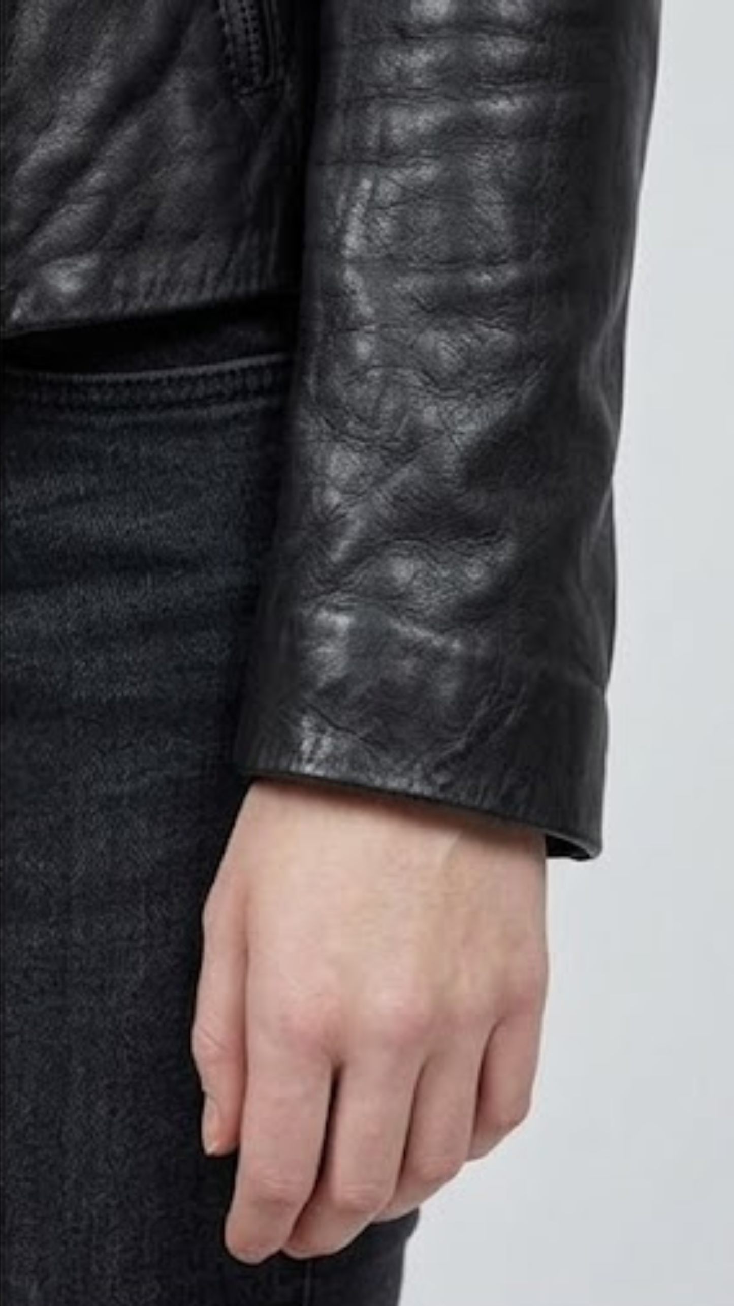 Close-up shot highlighting the smooth texture of the premium black leather and high-quality stitching on the blazer pocket.