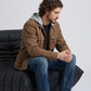 Men's heavy-duty street fashion featuring a structured dark tan hooded workwear coat styled for a rugged look.