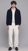 Full front view of model wearing a dark navy blue cotton jacket with a sleek front zipper and stand collar