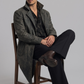 Men's edgy vintage fashion showcasing a structured charcoal grey distressed leather long coat styled for a bold look.