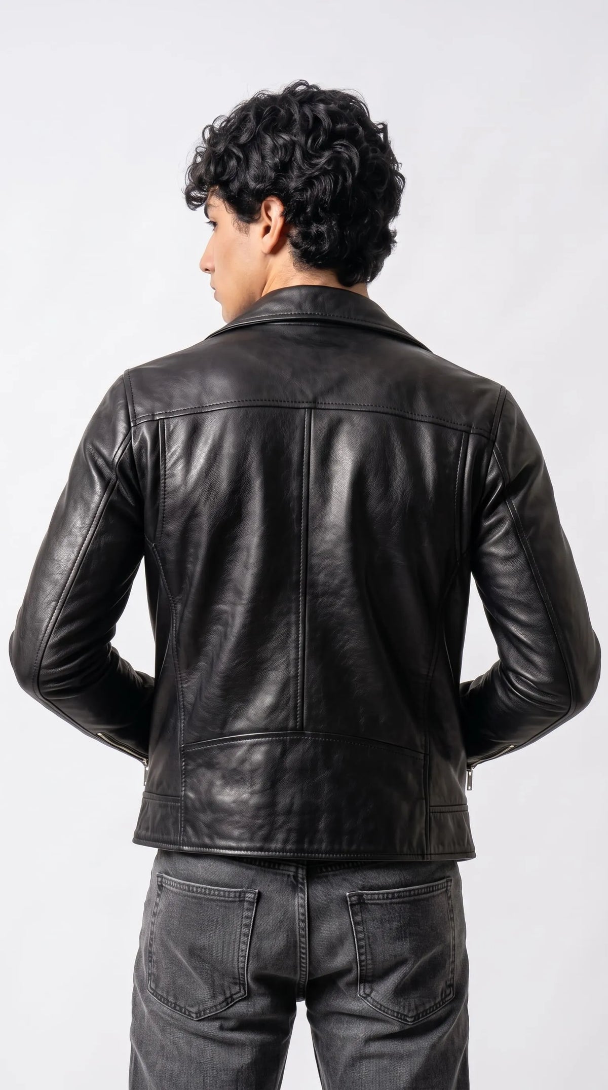 Men’s black genuine leather biker jacket with precisely stitched shoulder panels, clean vertical seams and a structured waist-length hem, creating a streamlined silhouette for modern minimalist outfits and elevated everyday menswear.