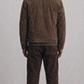 Rear view of a structured dark brown suede trucker jacket showing clean stitching and premium finish.