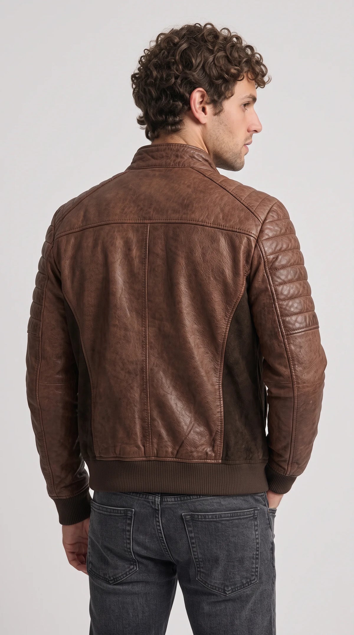 Men’s dark brown suede racer jacket featuring a clean stand-up neckline, rich chocolate colouring, contrasting quilted leather sections and a streamlined shape, ideal for layering over a fine-knit sweater or premium T-shirt for understated smart casual style.