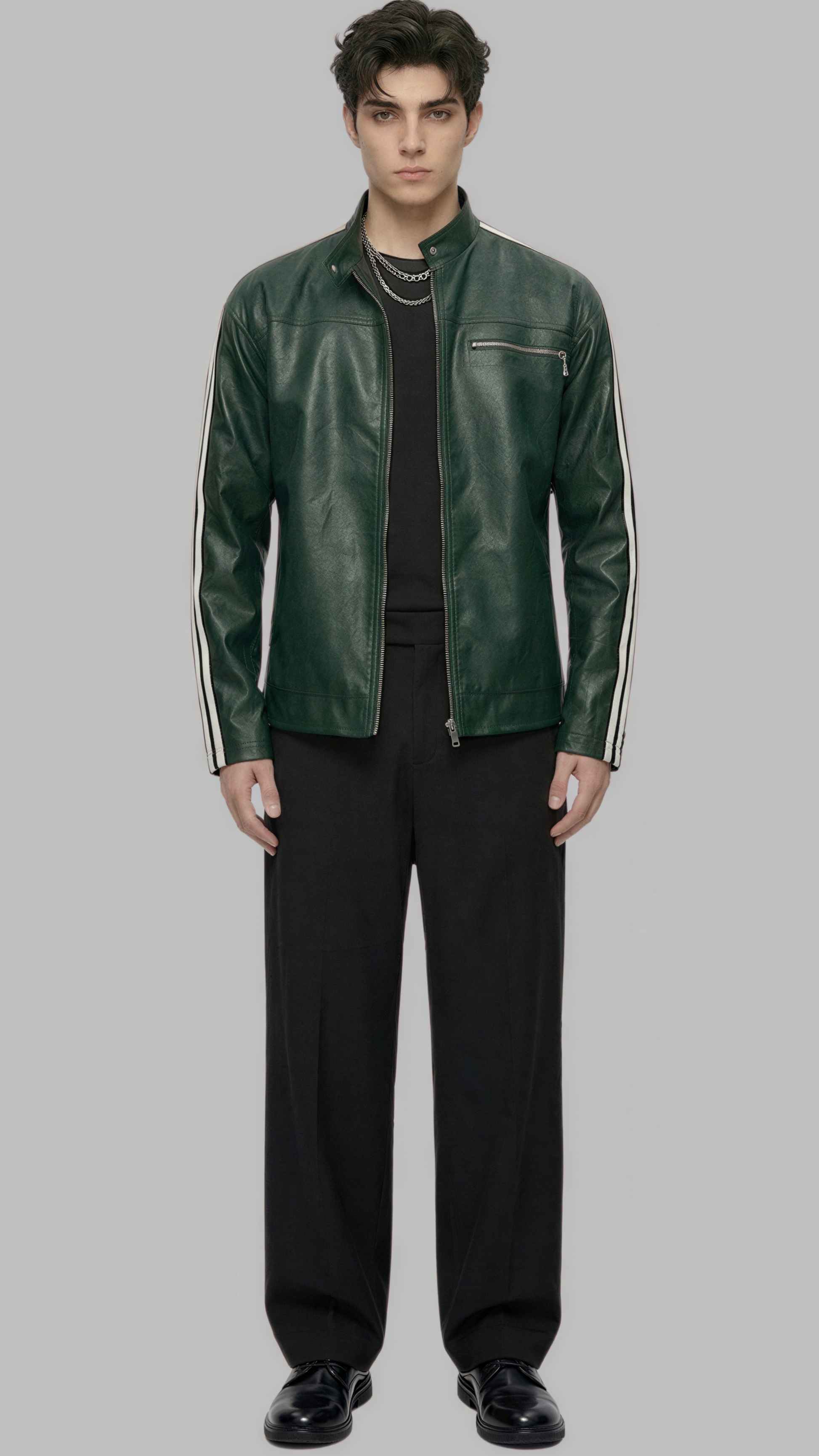 A male model wearing a dark green leather jacket with white stripe details on the sleeves, styled with a black shirt, black trousers, and black shoes, set against a solid gray background.