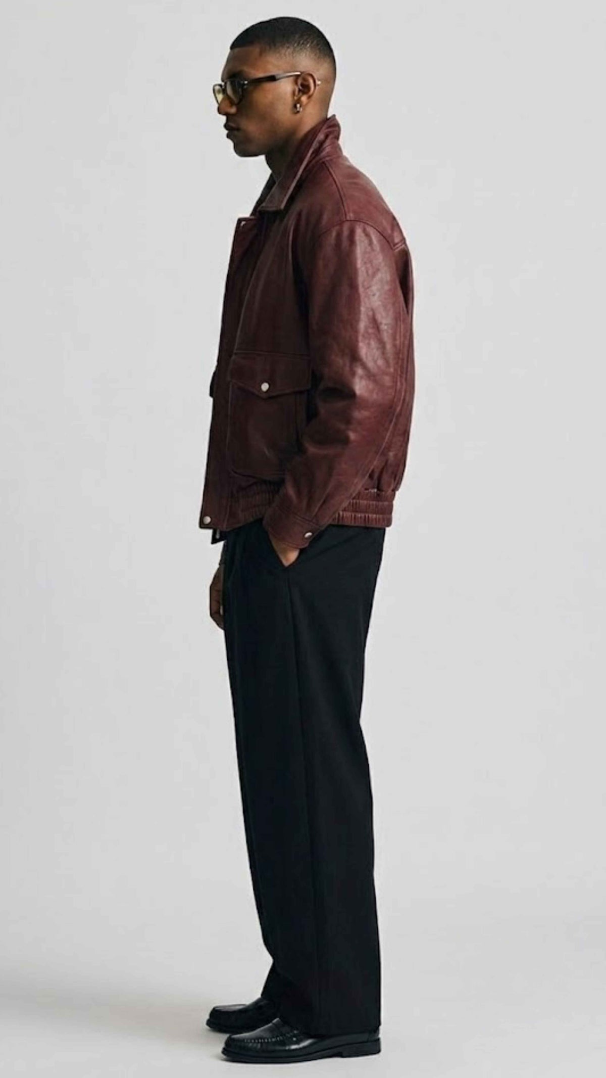 High-resolution detail of rich dark red leather grain finish and durable structural seam stitching.