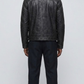 Straight-on back view of a structured plain black leather jacket highlighting its smooth surface, precise panel lines, and fitted silhouette.