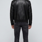 Symmetrical rear view studio shot highlighting the uniform tailoring and smooth premium leather panels of the sleek black flight coat.