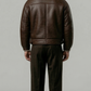a high-quality dark brown leather flight coat showing clean panel stitching and the contrast cream fur collar design.