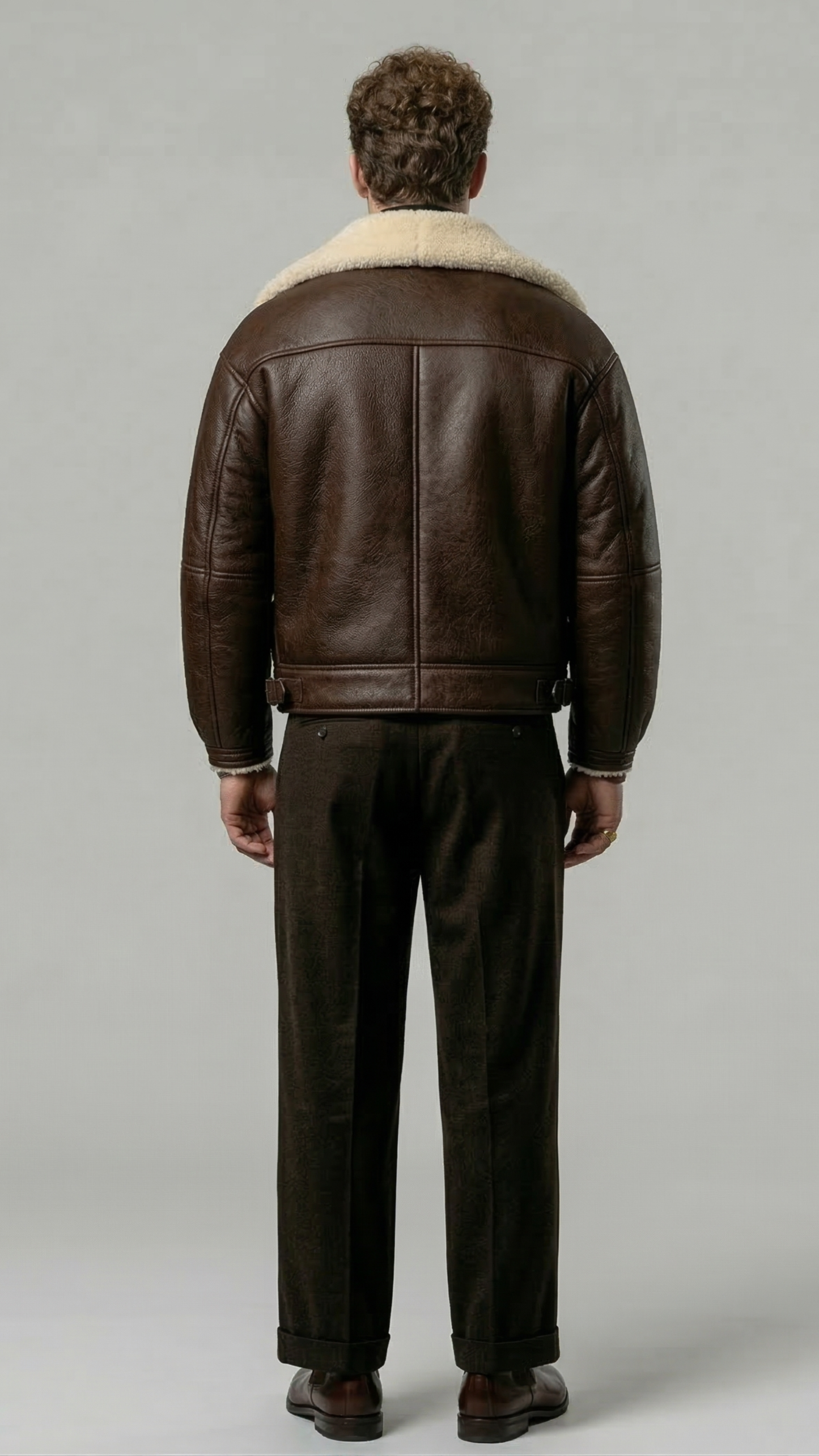 a high-quality dark brown leather flight coat showing clean panel stitching and the contrast cream fur collar design.