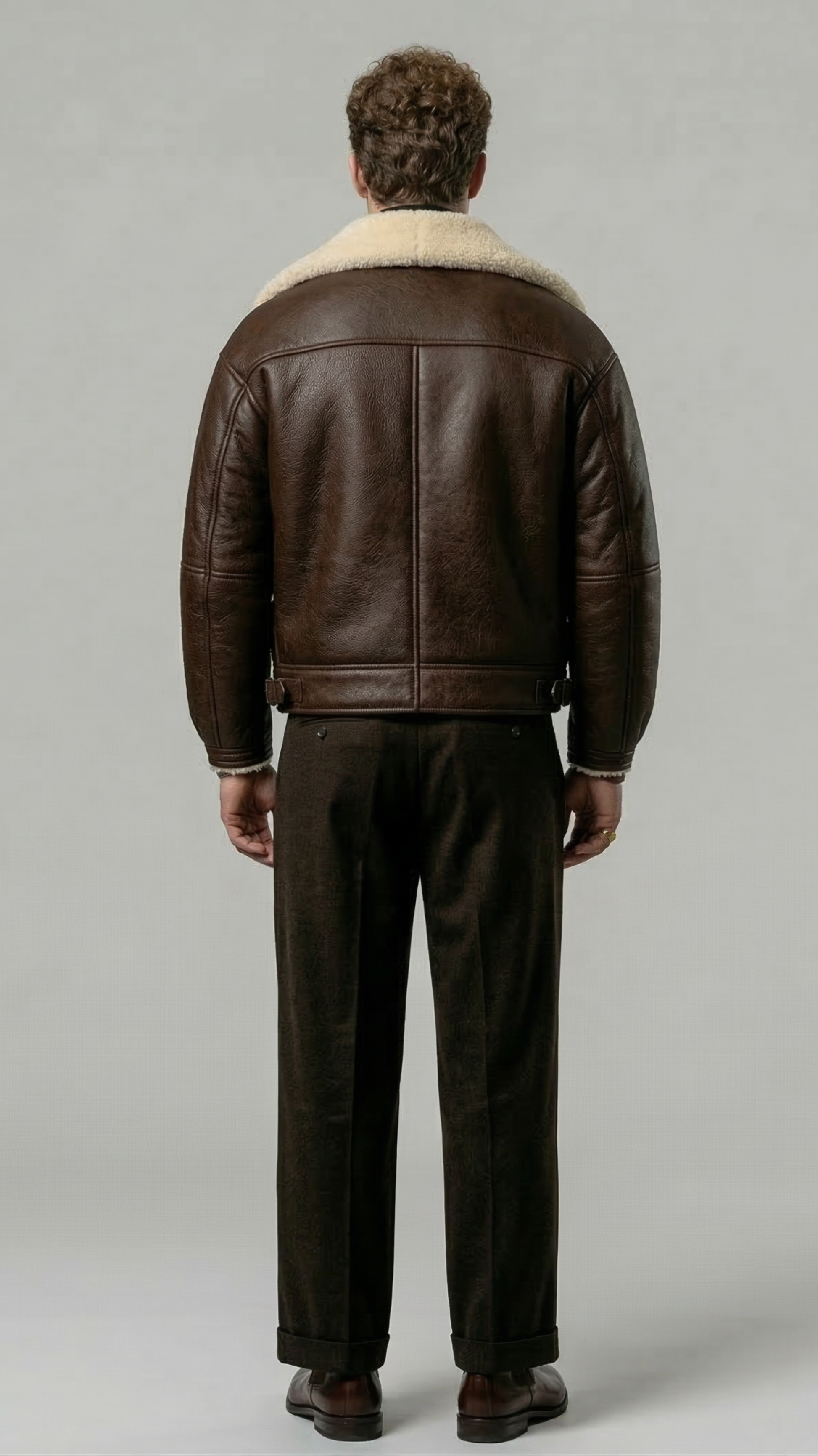 a high-quality dark brown leather flight coat showing clean panel stitching and the contrast cream fur collar design.