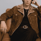 the structured fur collar, durable metallic front zip, and deep welt side pockets on a mustard suede coat.