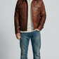 Front view lookbook photography of a model showcasing the Jackero premium dark tan brown distressed leather jacket styled with modern rugged streetwear.