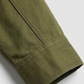 Close-up of a green cotton jacket sleeve on a white background
