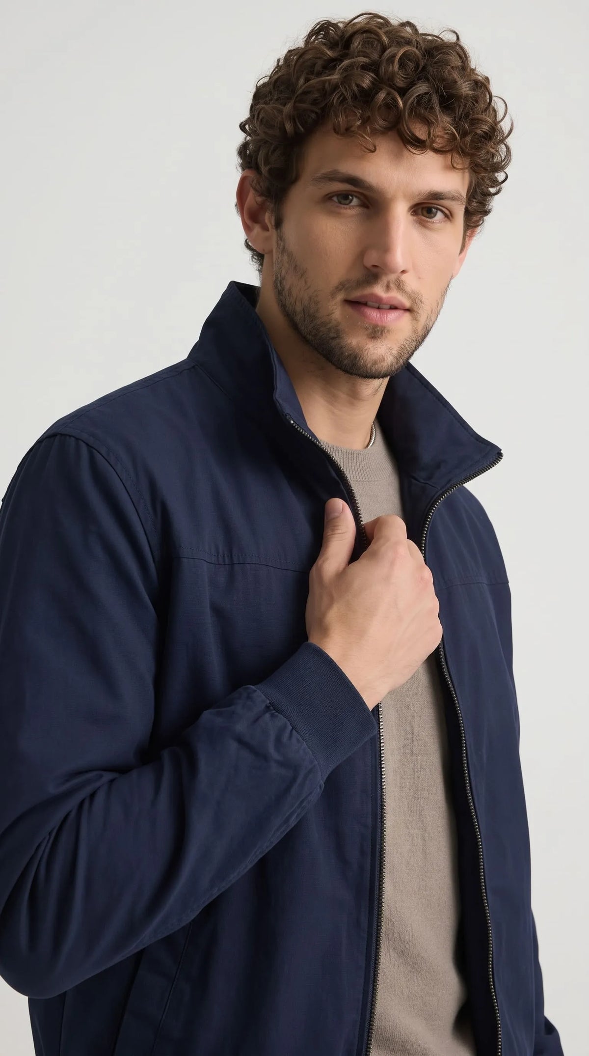 Close-up of a midnight navy cotton jacket highlighting its structured stand-up collar, polished metal zipper, neatly finished shoulder seam and smooth woven fabric. The understated dark-blue colour and practical high-neck design give this men’s zip-front jacket a polished minimalist look, ideal for layering over knitwear or a simple T-shirt in modern casual wardrobes.