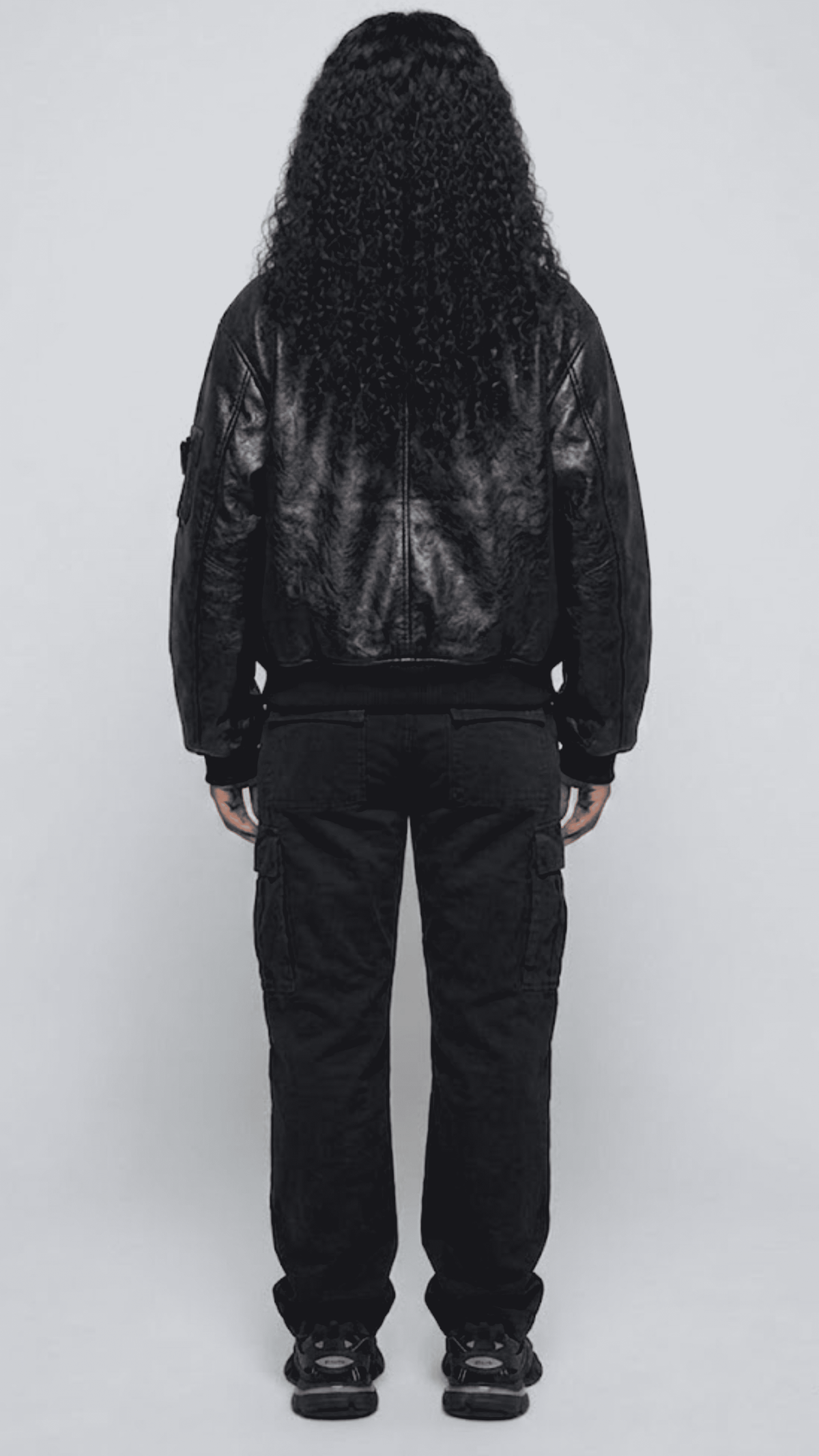 Clean back angle of a structured black leather bomber coat, highlighting the relaxed fit shoulders and tapered ribbed waist bottom alignment.