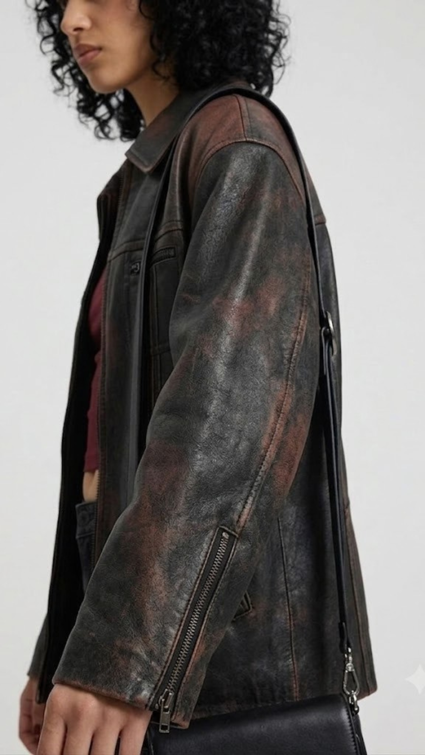 Close-up macro view highlighting the rugged, worn-in texture of premium distressed black leather and fine contrast stitching.