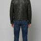 Straight-on back view of a structured black leather trucker jacket showcasing its minimalist paneling and clean aesthetic.