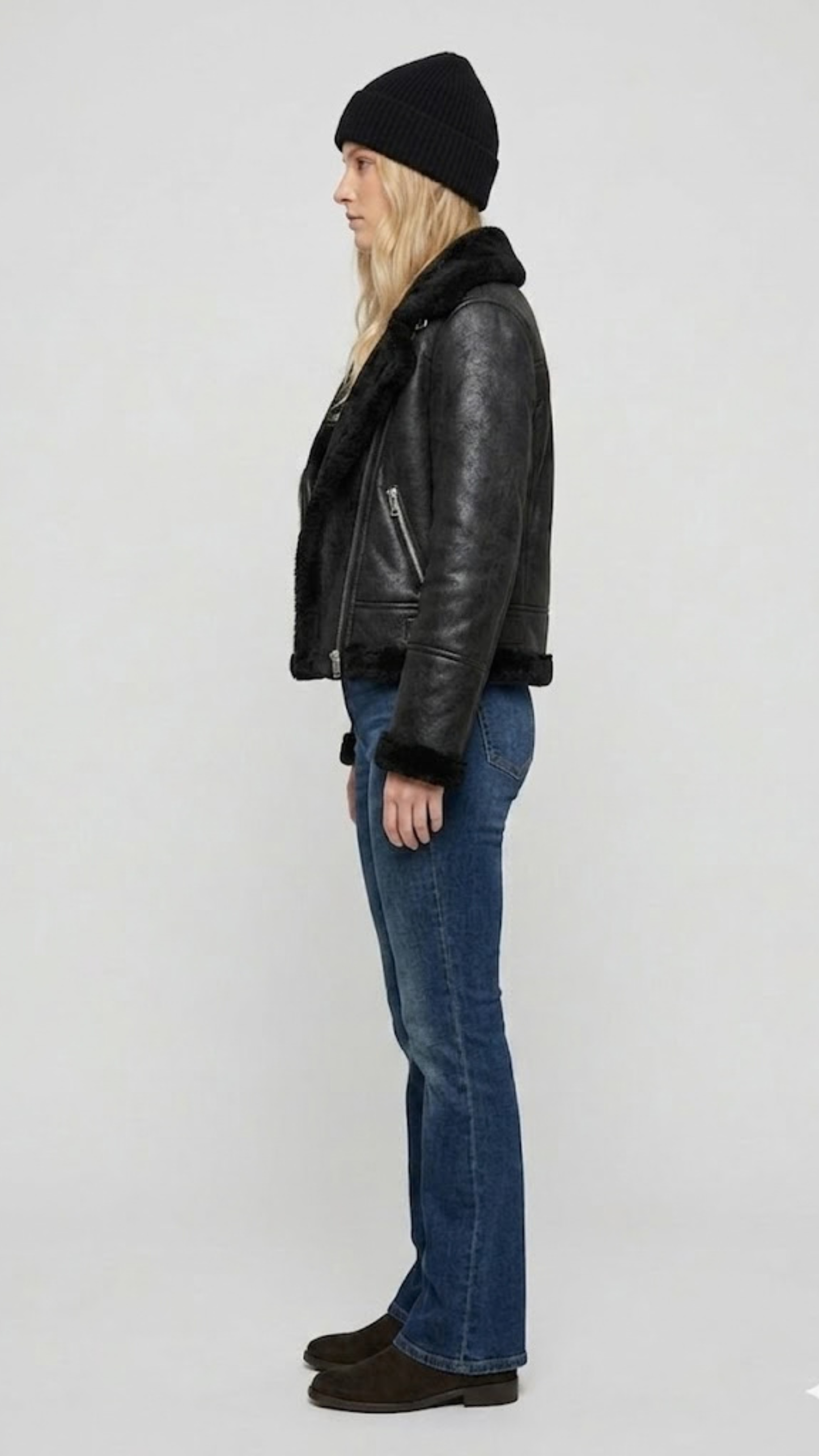Model wearing a stylish black leather aviator jacket with a warm fur collar for a rugged winter streetwear look.