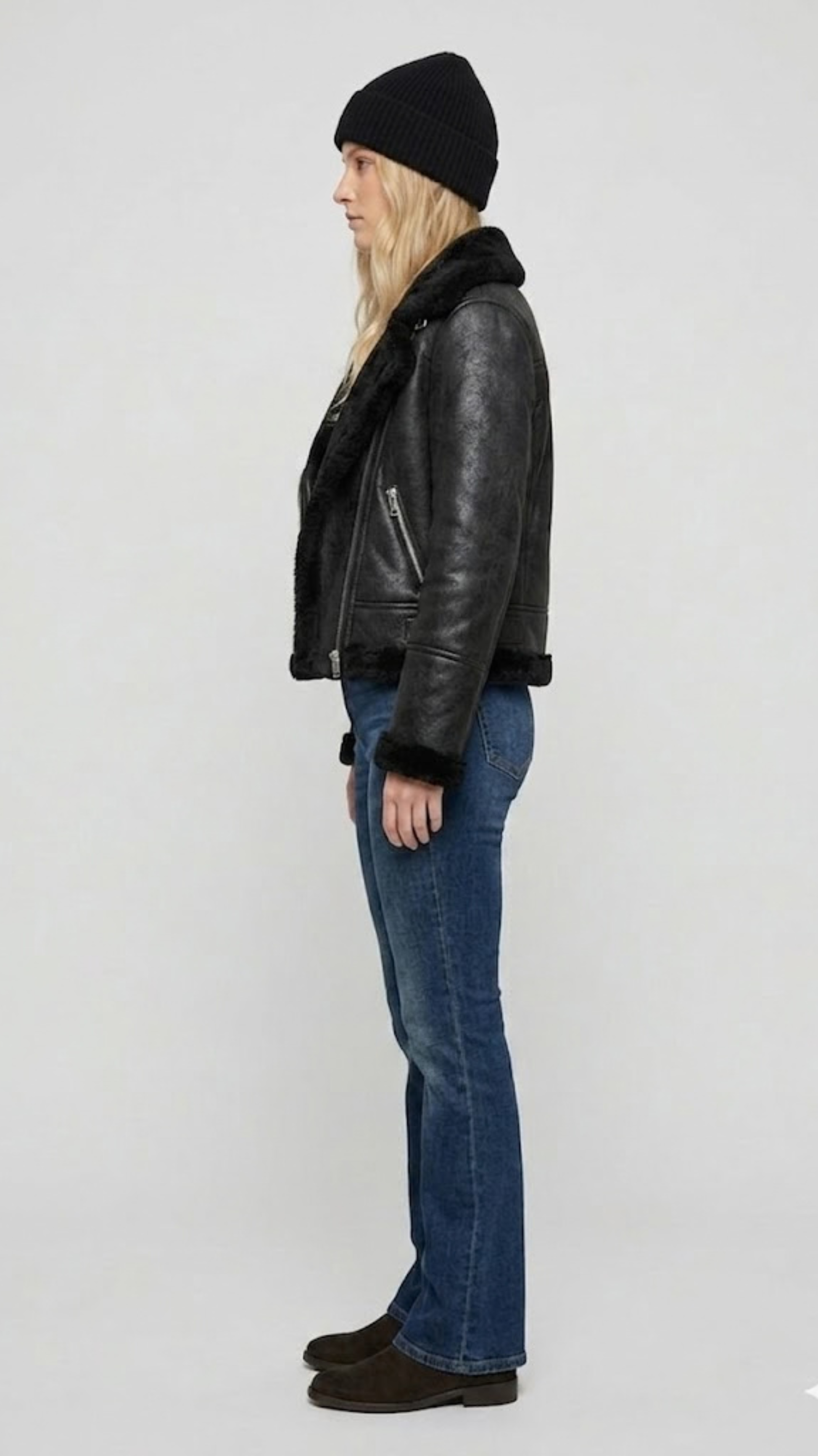 Model wearing a stylish black leather aviator jacket with a warm fur collar for a rugged winter streetwear look.