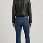Clean back view of a minimalist black leather biker jacket, highlighting the structured shoulders, tailcoat cut, and tailored fit alignment.