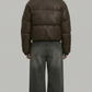 a high-quality chocolate brown winter coat highlighting the insulated puffer design and robust stitching details.
