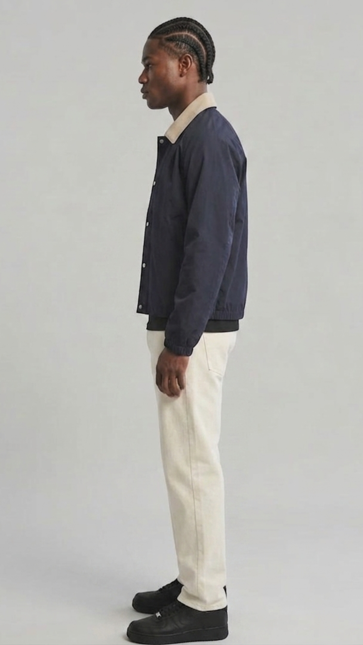 Urban lifestyle fashion photography of a casual layered men's look styled with a breathable dark navy cotton windbreaker jacket.