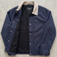 flat lay display featuring a neatly folded premium dark navy blue coach jacket for a clean online catalog layout.