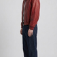Premium streetwear fashion lookbook featuring a high-quality red leather bomber jacket with front zipper.