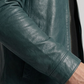 Close-up of a dark cyan leather jacket sleeve on a plain background