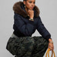 Detailed view of elasticated ribbed waistband, cuffs, and custom metal zipper on navy cropped outerwear