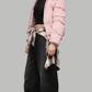 Minimalist lookbook style photography of a lightweight yet highly insulated pink puffer coat with a fur hood on a clean neutral backdrop.