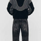 Back view showing full silhouette and structured seams of black and dark grey colorblock wool fleece coat.