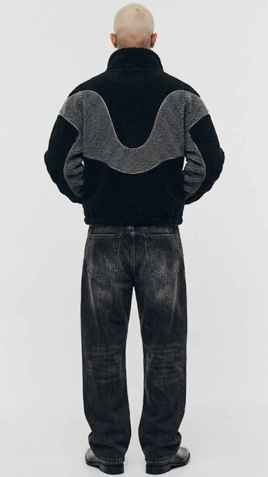 Back view showing full silhouette and structured seams of black and dark grey colorblock wool fleece coat.