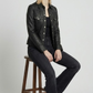 Detailed studio shot highlighting the symmetric chest flap pockets, sharp point collar, and precise stitching of a premium black leather jacket.