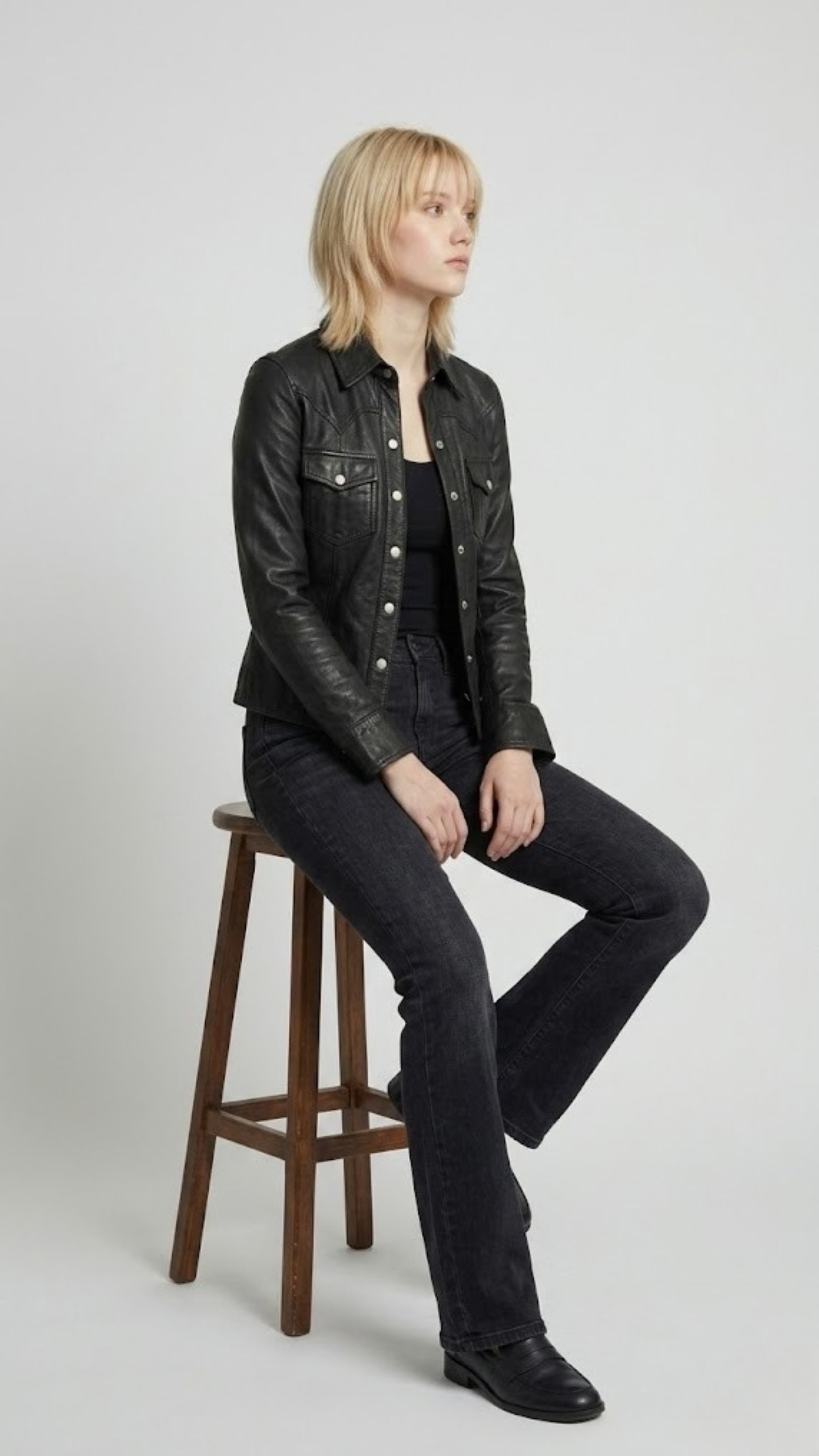 Detailed studio shot highlighting the symmetric chest flap pockets, sharp point collar, and precise stitching of a premium black leather jacket.