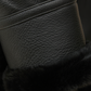Close-up of a black leather jacket with fur lining on a dark background
