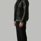 symmetrical side pose of a cozy black leather bomber jacket featuring an insulated grey shearling collar for wind protection.