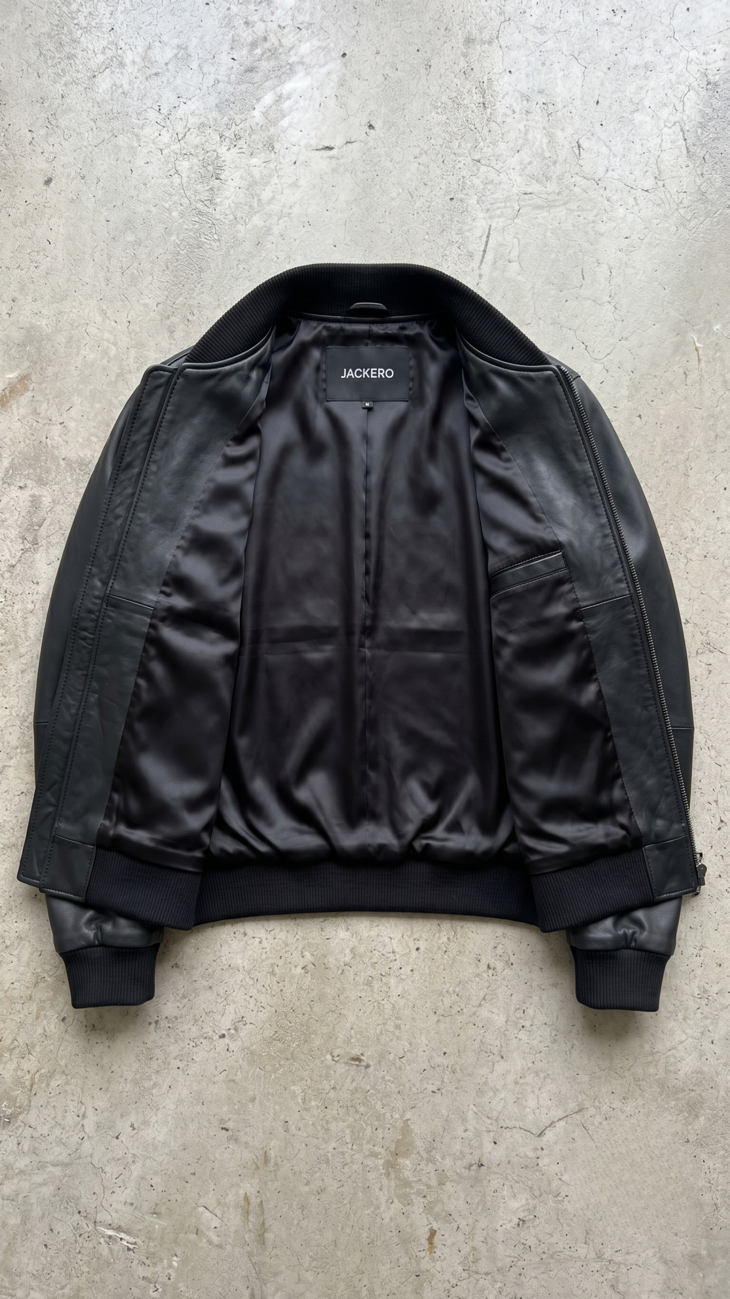 Professional studio product flat lay presentation displaying the premium black genuine leather casual bomber jacket arranged on a clean background.